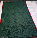 Attractive quilt with circular patterns, green fabric on a floor