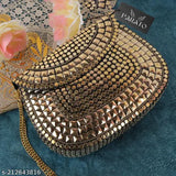This is a handbag with a golden metal chain design. It features multiple sequins, a large clutch section, and is displayed on a dark surface with a flower in the background. The bag has multiple compartments and a clasp closure