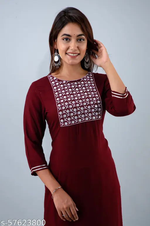 A woman wearing a maroon kurta set