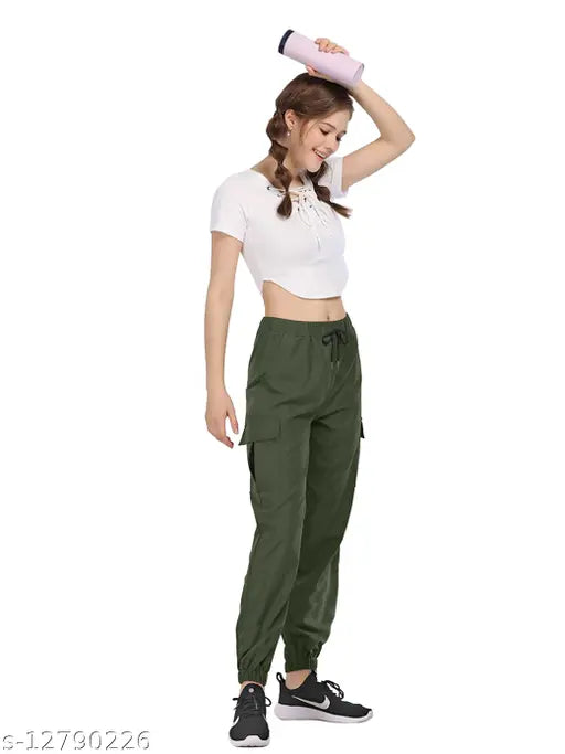 A woman wearing olive cargo pants, sporting a white tank top and black sneakers