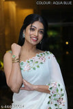 A woman in a sleeveless dress with a floral pattern and a matching dupatta, smiling and posing