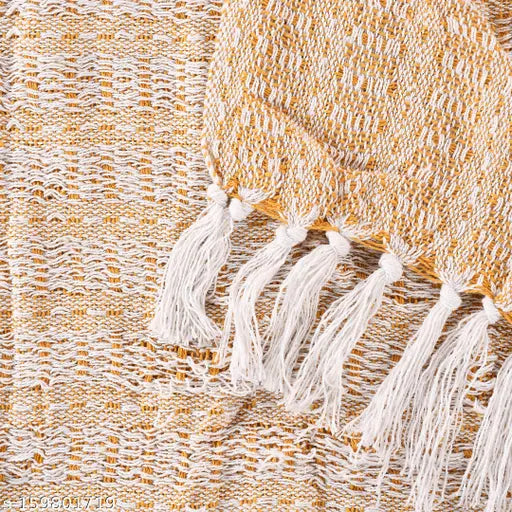 A yellow cotton throw bedcover with fringe ends