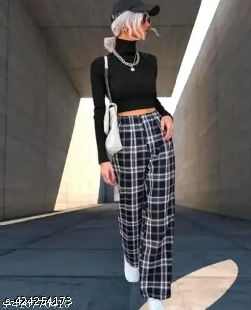White and black plaid pants, black sweater, cap, purse