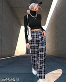 White and black plaid pants, black sweater, cap, purse