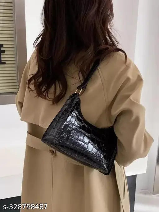 Black sling bag with strap, featuring a shiny crocodile texture