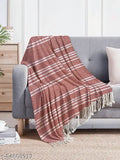 Red fringe blanket with a white pillow and wall behind it
