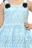 A blue frock with a floral pattern for baby girls, styled with a clutch handbag