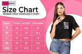 A woman wearing a pink crop top with a graphic design on one half sleeve, displaying size chart in the background