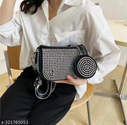 Black polka dot purse with a chain strap and coin purse, featuring a shoulder strap for cross-body wear