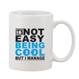 White ceramic coffee mug with printed quote: "It's not easy being cool, but I manage