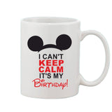 A white ceramic coffee mug with a handle, featuring a printed graphic of black text on a red background that reads 'I CAN'T KEEP CALM IT'S MY BIRTHDAY!' and a small minnie mouse icon