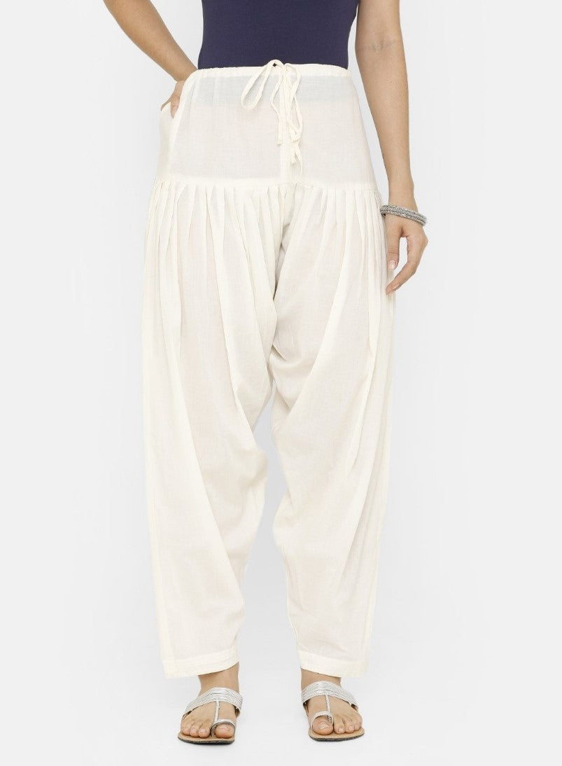 A person is wearing white patiyala cotton trousers